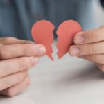 close up hands holding broken heart